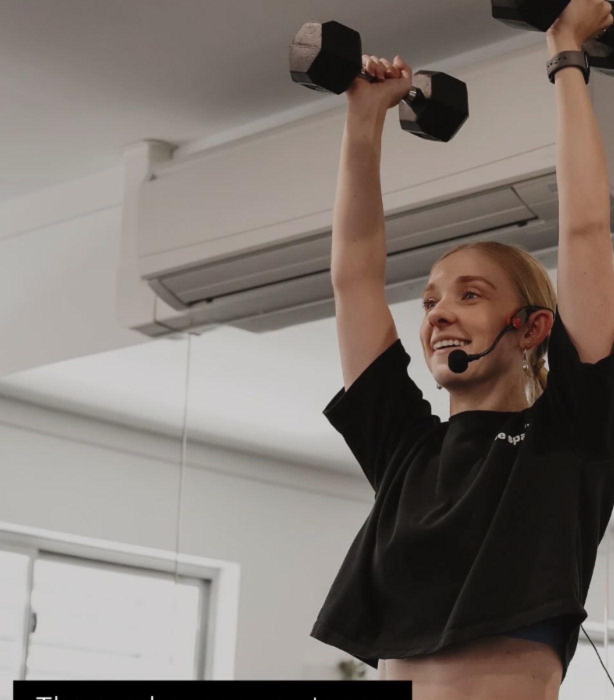 An instructor demonstrating a dumbbell exercise on the reformer