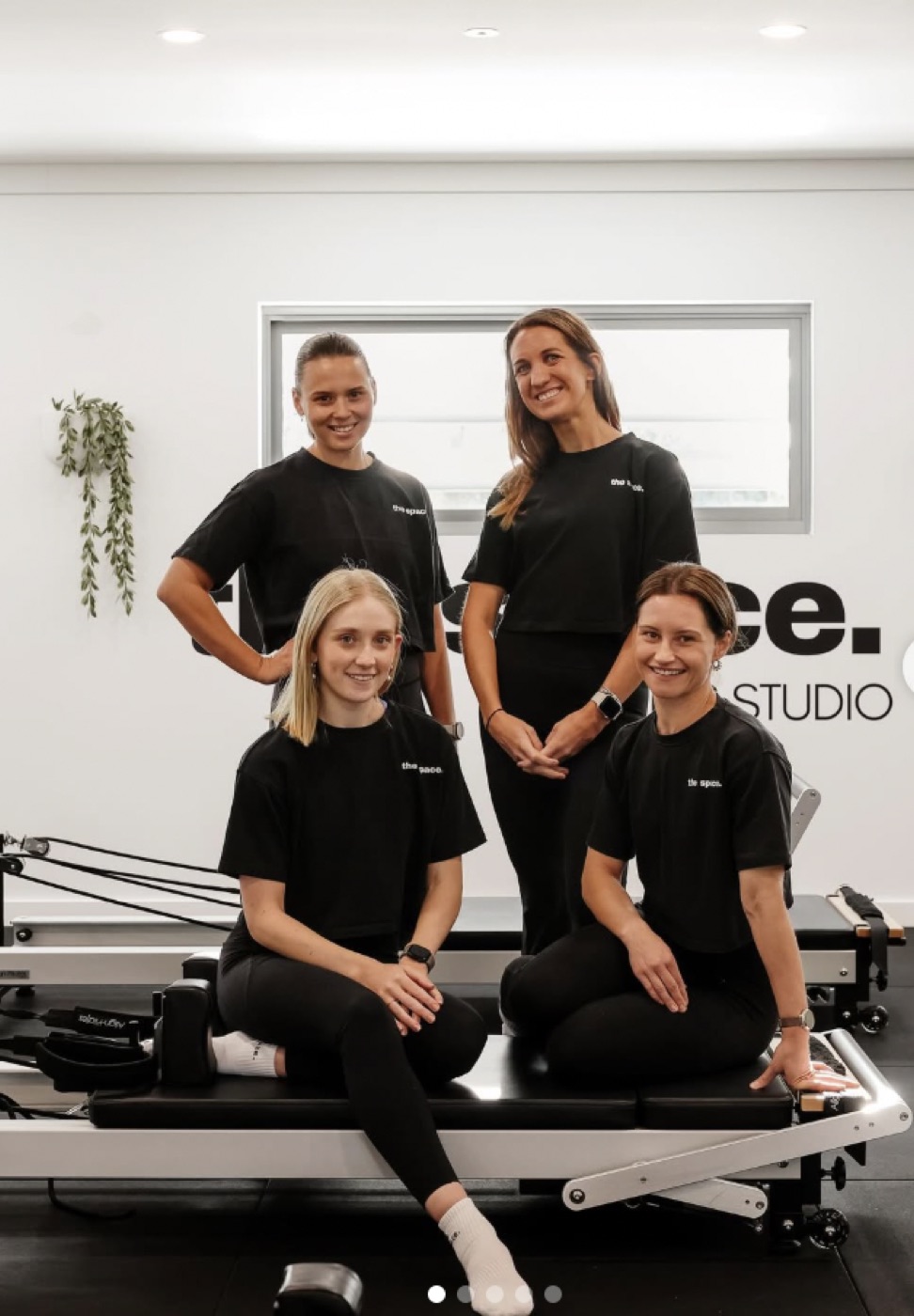 The four instructors of The Space Pilates Studio seated on a reformer